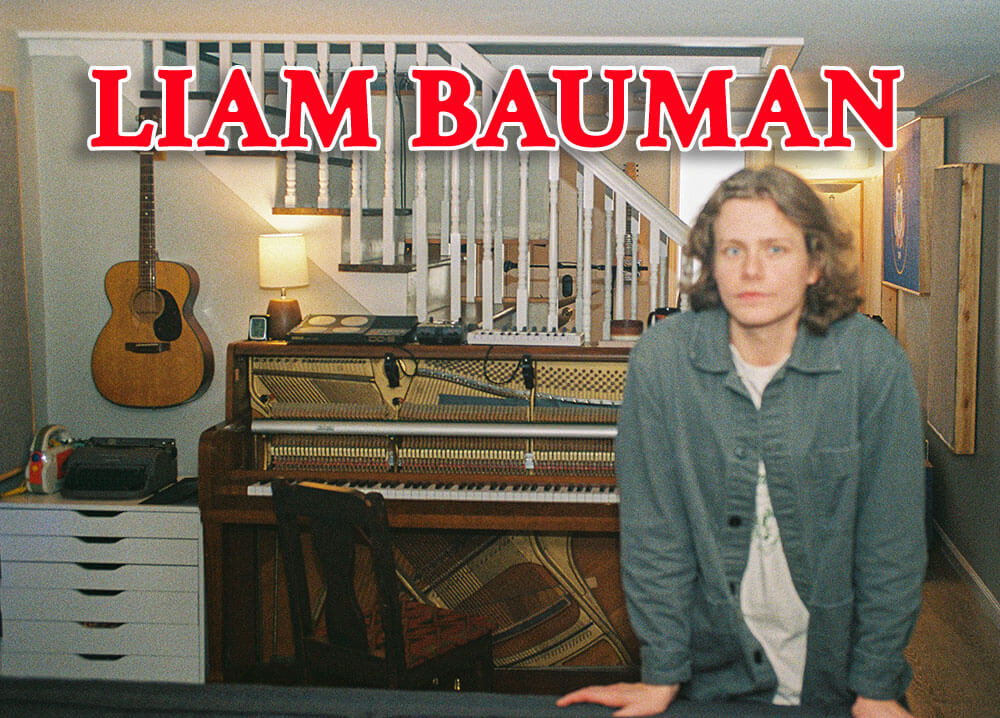 Liam Bauman standing in front of a piano and guitar